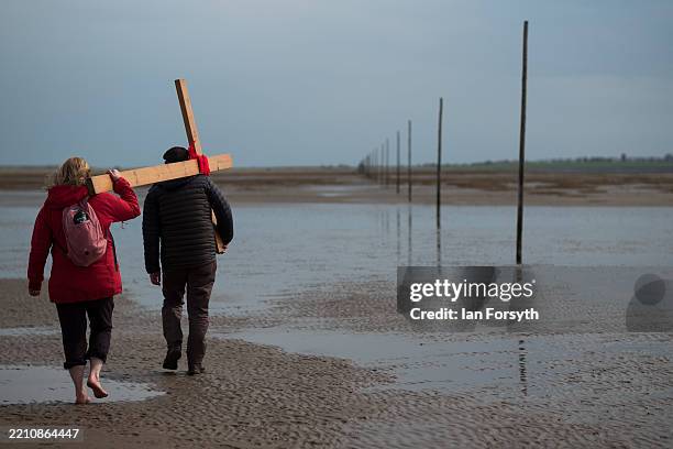 Pilgrims celebrate Easter by carrying wooden crosses as they walk over the tidal causeway to Lindisfarne during the final leg of their annual Good...