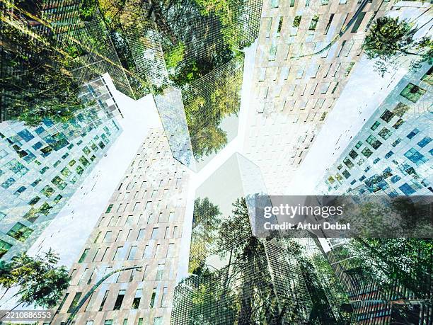 urban symbiosis with a modern skyscrapers merging with the nature - bâtiment écologique photos et images de collection