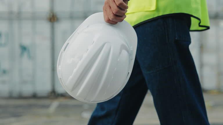 https://media.gettyimages.com/id/2210918739/video/close-view-of-a-construction-worker-walking-near-container-terminal-and-carrying-helmet.jpg?b=1&s=640x640&k=20&c=hhqHlspB4P923_ycwpKXTnpYgwdlZI9xVSPWxbgKncI=