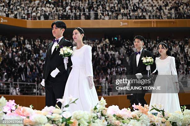 This picture taken on April 12, 2025 shows couples attending a mass wedding ceremony organised by the Unification Church at Cheongshim Peace World...