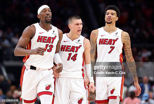 Bam Adebayo, Tyler Herro and Kel'el Ware of the Miami Heat react against the Atlanta Hawks during the third quarter of an NBA play-in tournament game...
