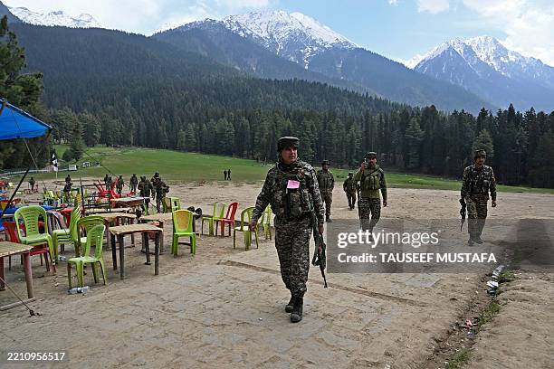 Security personnel inspect the site in the aftermath of an attack as food stall chairs lie empty in Pahalgam, about 90km from Srinagar on April 23,...