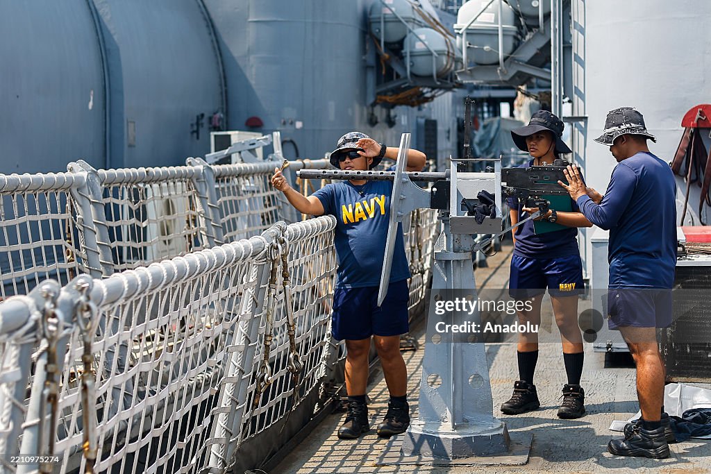 Multilateral Machine Philippine Navy personnel onboard a warship install machine guns, as ...
