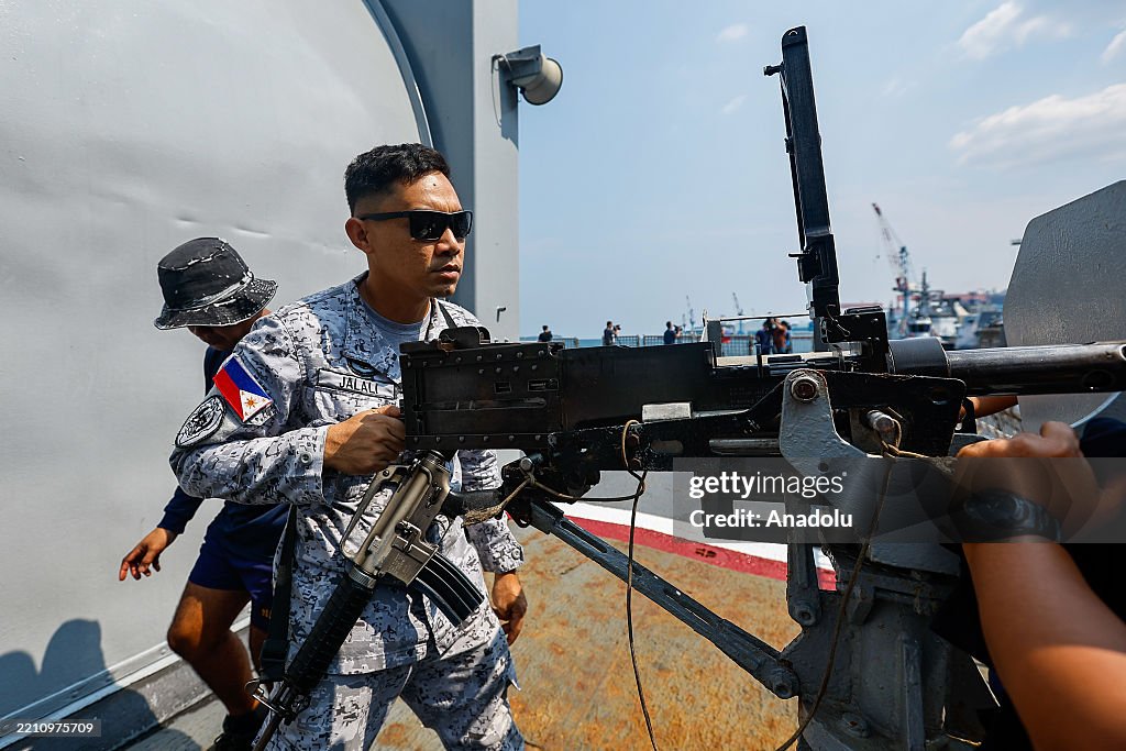 Multilateral Machine Philippine Navy personnel onboard a warship install machine guns, as ...