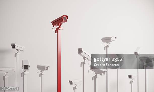 red colored security camera standing out from the crowd - bewakingscamera stockfoto's en -beelden