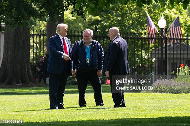 President Donald Trump walks and speaks with staff on the North Lawn of the White House in Washington, DC, on April 23 as he surveys for a location...
