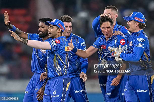 Mumbai Indians' Trent Boult celebrates with teammates after taking the wicket of Sunrisers Hyderabad's Travis Head during the Indian Premier League...