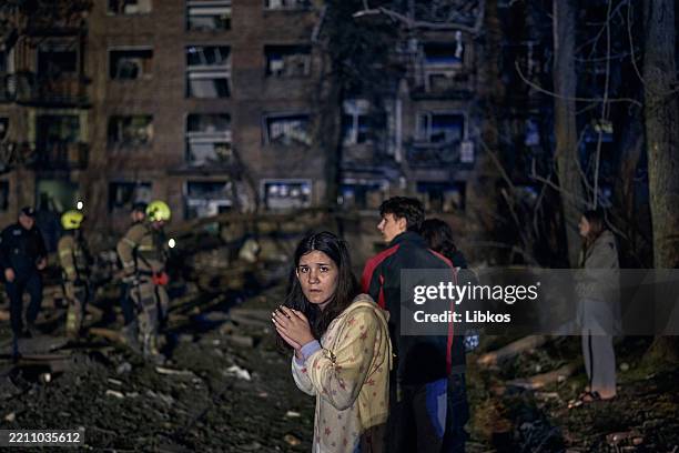 Rescuers and civilians worked to pull victims from the rubble of a missile strike on a residential building resulting in two deaths and 54 injured on...