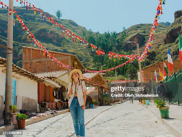 woman walking in small town in urubamba valley during trip to peru - cusco city stock pictures, royalty-free photos & images