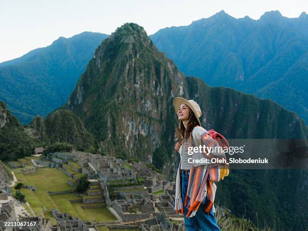 woman looking at awe-inspiring view of machu pichu in peru - wonder stockfoto's en -beelden