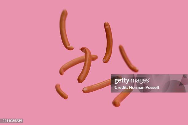 bavarian sausages falling against pink background - wurst stock-fotos und bilder