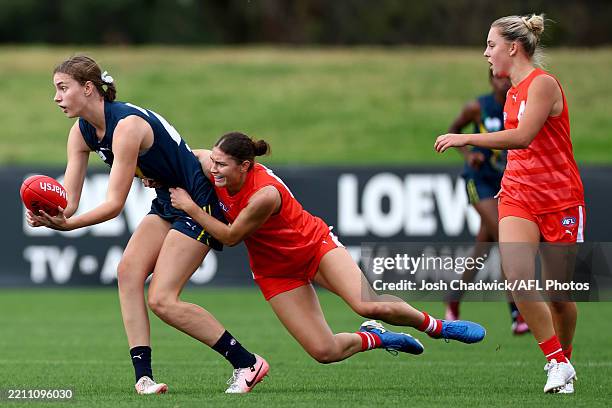 Madeleine Quinn of the AFL National Academy handballs whilst being tackled by Ellie Veerhuis of the All-Stars during the Marsh AFL National Academy...