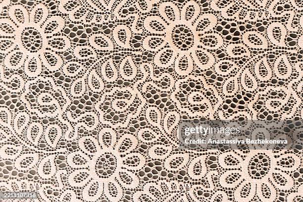 background of beige lace fabric with expressive patterns on a black background - encaje fotografías e imágenes de stock