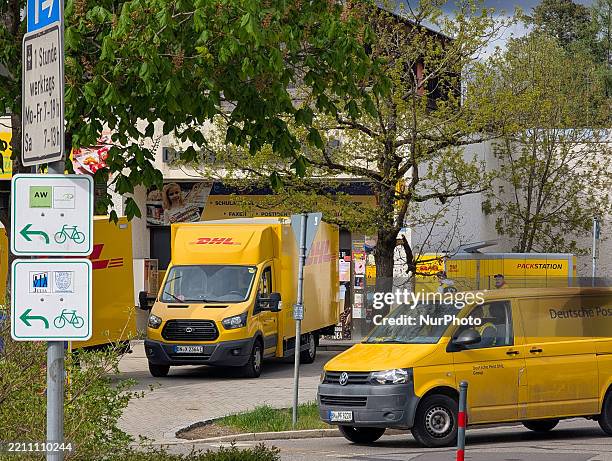 And Deutsche Post employees load and unload parcels at a DHL Packstation and transport packages using service vans in Gauting, Upper Bavaria,...