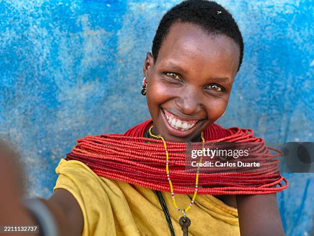 smiling maasai woman taking a selfie with traditional red necklace - kenyan culture stock pictures, royalty-free photos & images