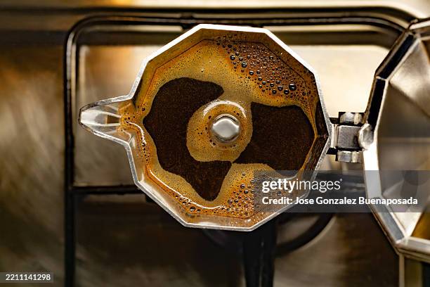 café recién hecho llenando una cafetera moka en la estufa - cafetera moka fotografías e imágenes de stock