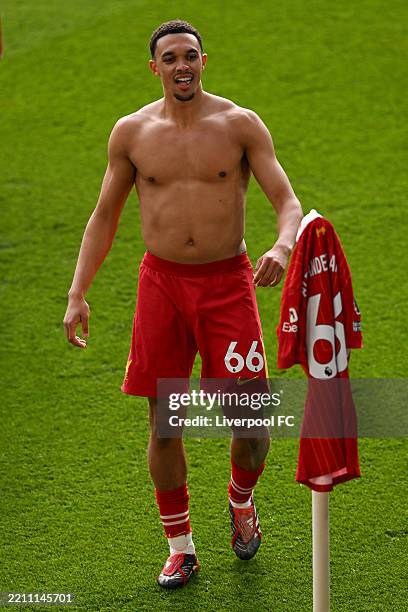 Trent Alexander-Arnold of Liverpool celebrates scoring his team's first goal by placing his match shirt on the corner flag during the Premier League...