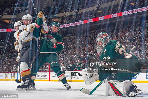 Filip Gustavsson makes a save while his teammate Brock Faber of the Minnesota Wild defends against Ivan Barbashev of the Vegas Golden Knights during...