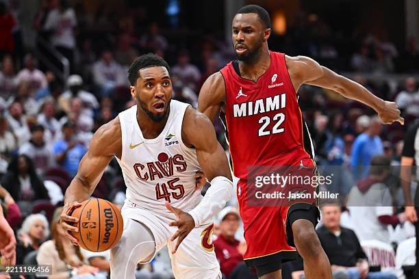 Donovan Mitchell of the Cleveland Cavaliers drives to the basket around Andrew Wiggins of the Miami Heat during the third quarter of game one of the...