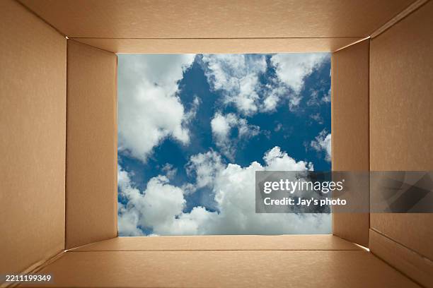 looking though cardboard open box toward blue sky background. - crate texture stock pictures, royalty-free photos & images