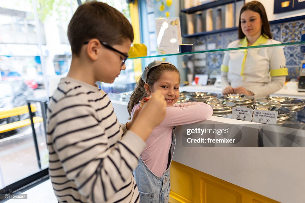 Brother and sister buying favorite flavors of ice-cream in parlor