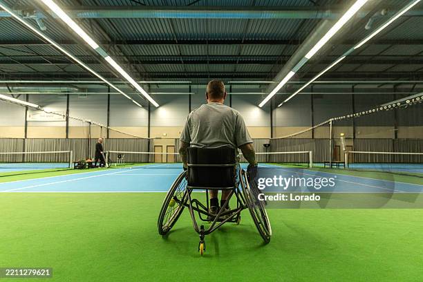 a handsome middle aged wheelchair tennis male player during an indoor session - wheelchair tennis stock pictures, royalty-free photos & images