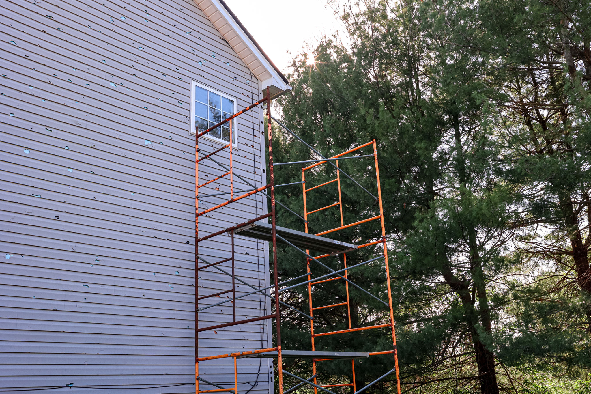 Scaffold On The Side of A House To Repair Vinyl Siding Scaffold On The Side of A House To Repair Vinyl Siding