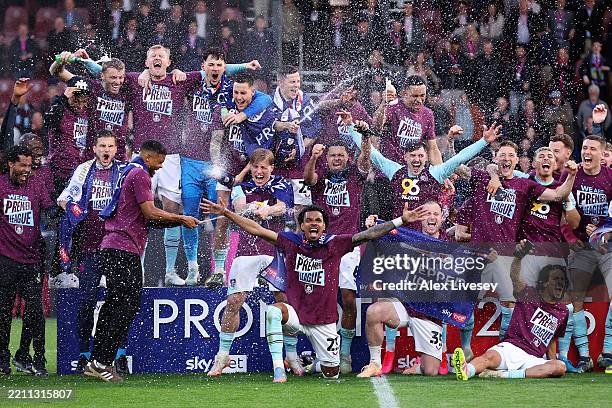 The players of Burnley celebrate with champagne following the team's victory and subsequent promotion to the Premier League in the Sky Bet...