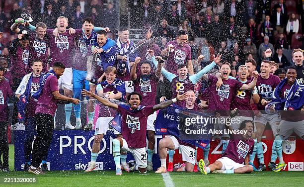 The players of Burnley celebrate with champagne following the team's victory and subsequent promotion to the Premier League in the Sky Bet...