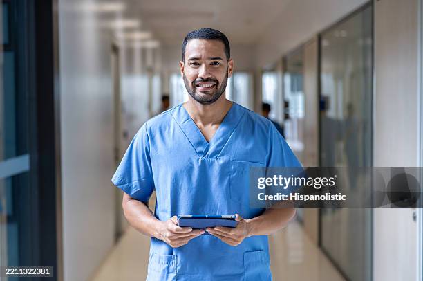 porträt einer krankenschwester, die im krankenhaus arbeitet und ein digitales tablet in der hand hält - medizinerkleidung stock-fotos und bilder