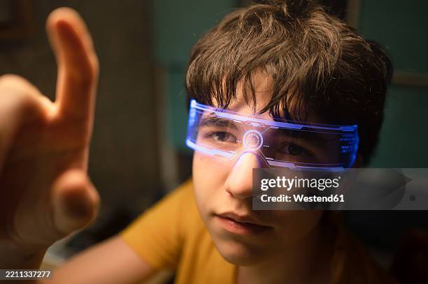 teenager wearing smart glasses interacting with virtual interface indoors - information equipment stock pictures, royalty-free photos & images