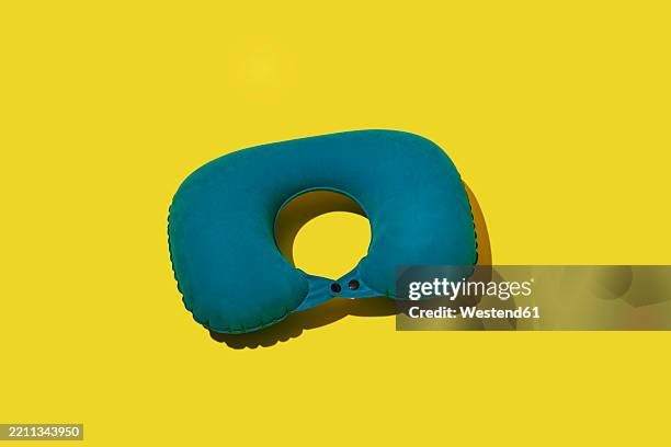 blue inflatable travel pillowon yellow background - head rest stock pictures, royalty-free photos & images