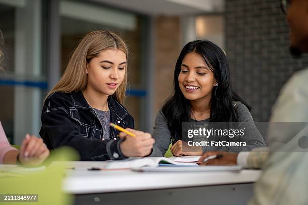 young students collaborating together while smiling and enjoying their study session - native indian stock pictures, royalty-free photos & images