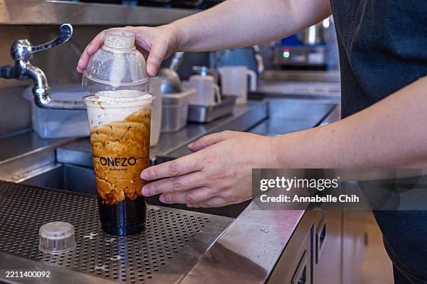 Staff finishes making a bubble tea at a bubble tea shop on April 22, 2025 in Tainan, Taiwan. The ongoing trade war, particularly between the US and...
