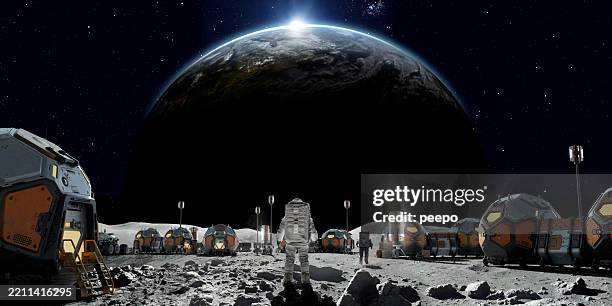 astronauts living on lunar base on moon - maan stockfoto's en -beelden