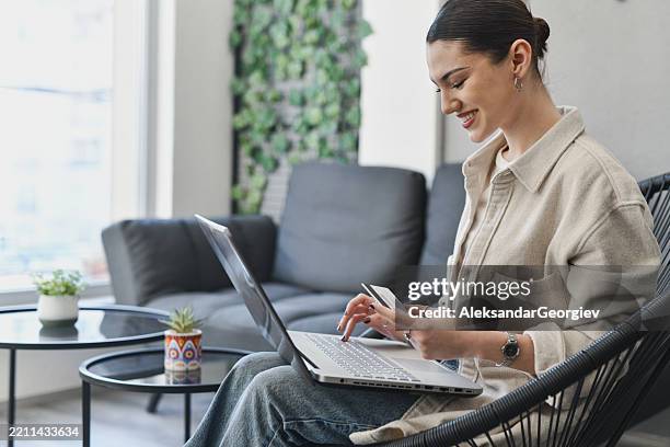 cheerful female paying for electricity bills online using credit card - subscription stock pictures, royalty-free photos & images