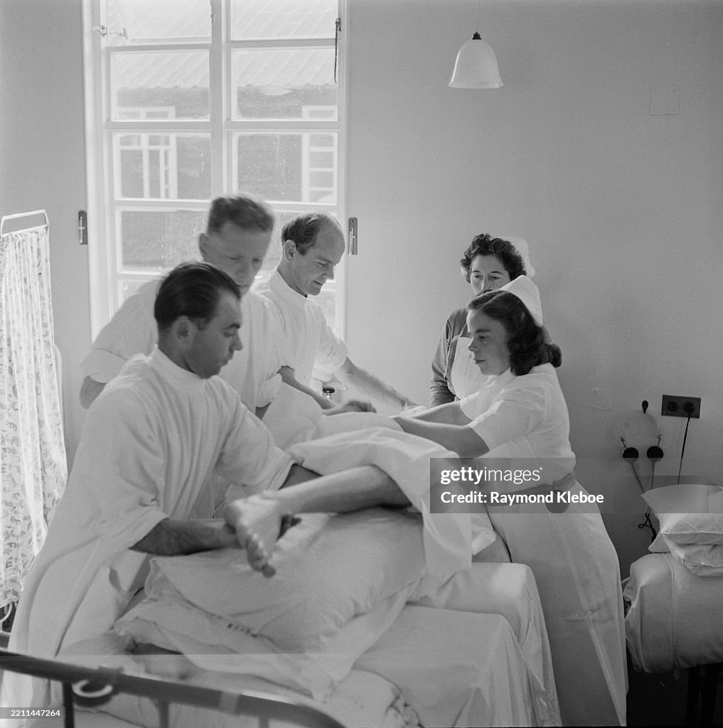 A Team Of Nurses Move A Patient With A Physical Disability From A a-team-of-nurses-move-a-patient-with-a-physical-disability-from-a