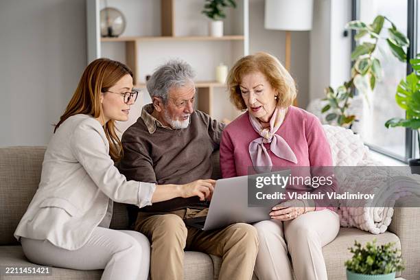 engager un couple de personnes âgées avec une femme sur un ordinateur portable ensemble - testament photos et images de collection