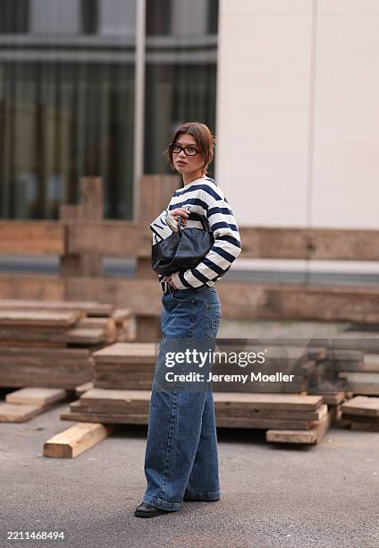 Sophia Geiss seen wearing Corlin Eyewear small rectangular glasses with a brown frame, Vogue Collection relaxed, long-sleeve white sweater with bold...