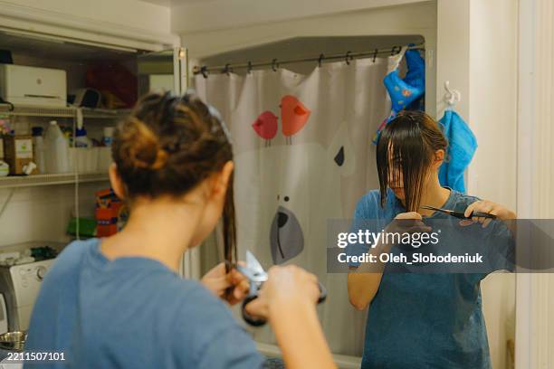 woman cutting herself bangs in the bathroom - cut hair stock pictures, royalty-free photos & images