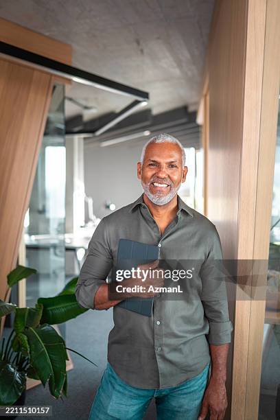 confident hispanic businessman engages with digital tablet - alleen één seniore man stockfoto's en -beelden