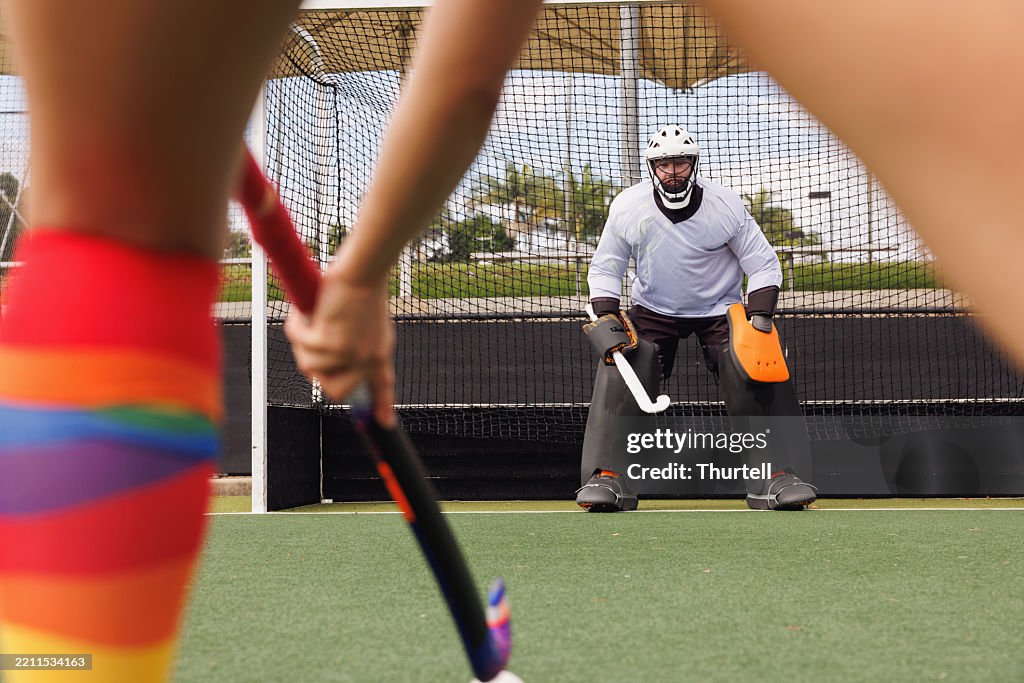 Field hockey goalkeeper focused on saving a goal