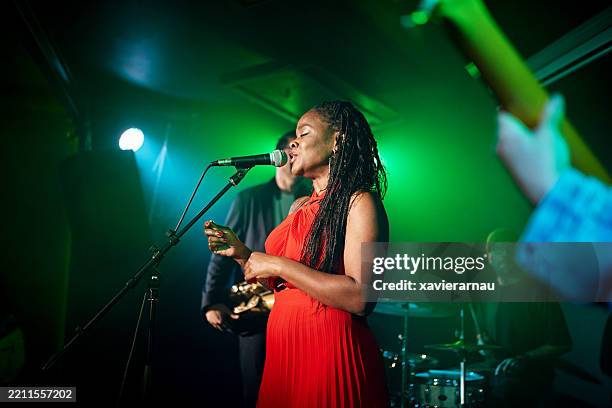 black chanteuse singing with band in nightclub - singer stock pictures, royalty-free photos & images