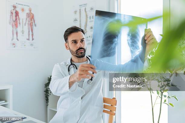 junger arzt x-ray analyse - menschliche lunge stock-fotos und bilder