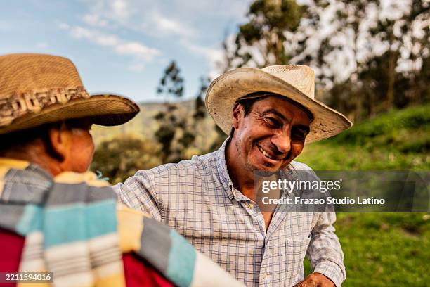 porträt eines reifen landwirts, der seinen vater auf einem bauernhof umarmt - kolumbianischer abstammung stock-fotos und bilder
