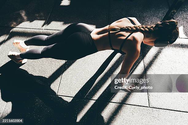 woman standing plank position in gym. - bodyweight training stock pictures, royalty-free photos & images