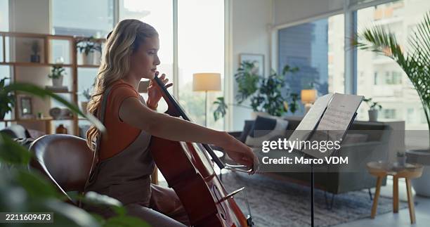 musician, music sheet and playing cello in home for performance guide, sound practice or learning song. string instrument, woman and rehearsal for concert recital, creative preparation or study notes - cello stock pictures, royalty-free photos & images