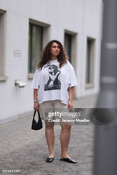 Vivien Blotzki is seen wearing an oversized white t-shirt with a black and white photo print, a bicolor watch with a rectangular case from Fossil, a...