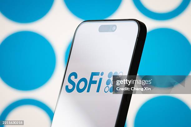 In this photo illustration, the logo of SoFi Technologies, Inc. Is displayed on a smartphone screen, with the company's signature blue branding and...