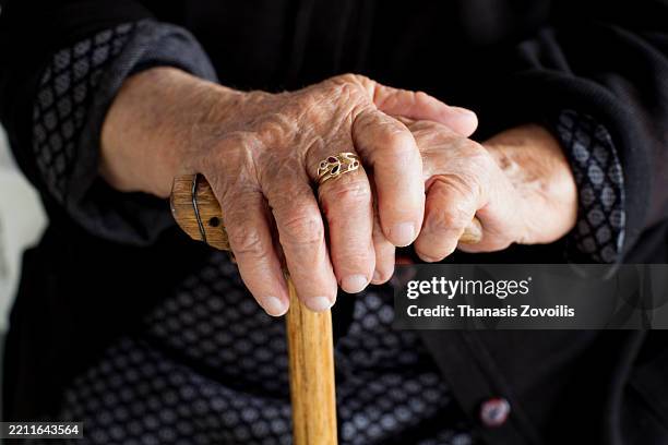 elderly woman's hands resting on a wooden cane with a ring - hand posture stock pictures, royalty-free photos & images